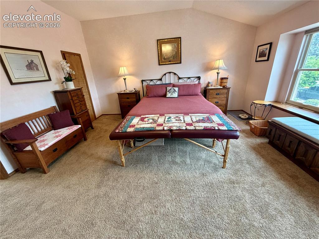 Image 28 of 49: Carpeted room featuring a sloped ceiling and a window with a built-in windo