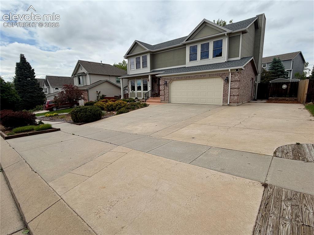 Image 3 of 49: Two-story residence featuring a brick and siding exterior, an attached two-