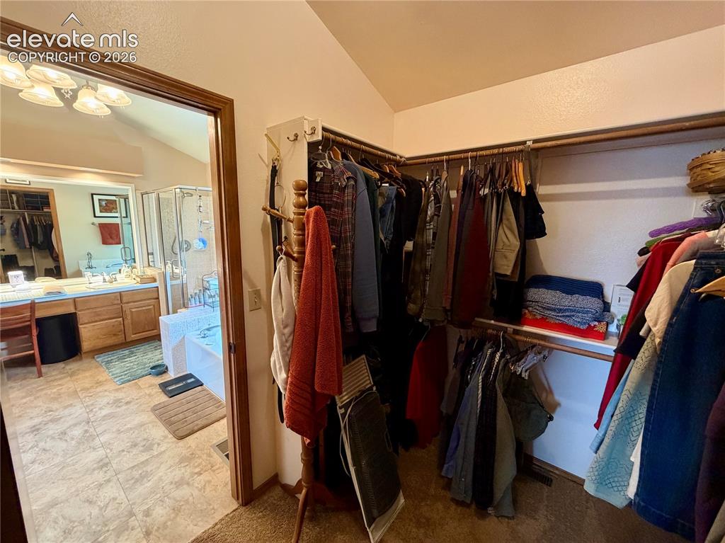 Image 32 of 49: Walk-in closet - Primary Suite-featuring carpet flooring, built-in shelving
