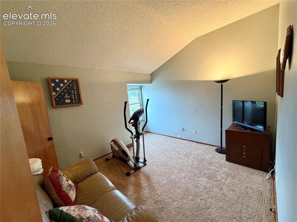 Image 34 of 49: Room featuring an angled ceiling, light-toned wall paint, and a window prov