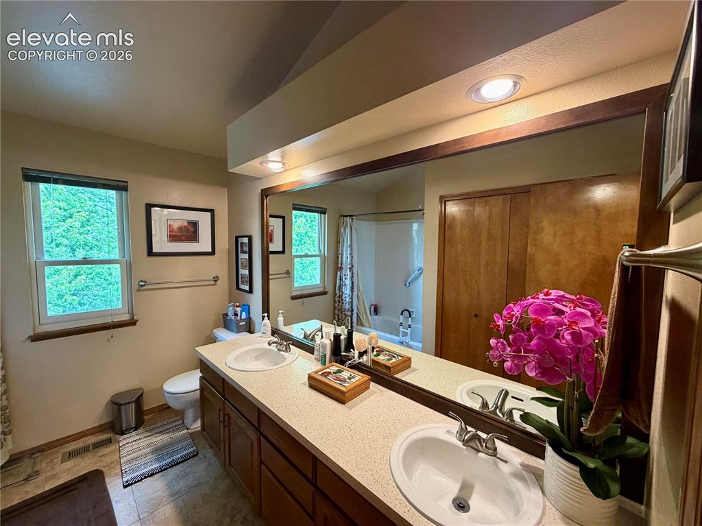 Image 37 of 49: Guest Bathroom-Dual-sink vanity with a speckled countertop, integrated ligh