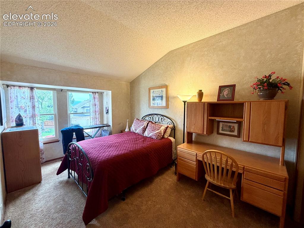 Image 38 of 49: Bedroom featuring a vaulted ceiling and windows with Mountain Views