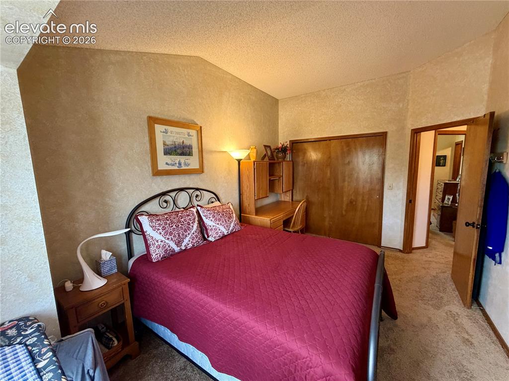 Image 39 of 49: Bedroom featuring textured wall treatments, wood-finish bi-fold closet door