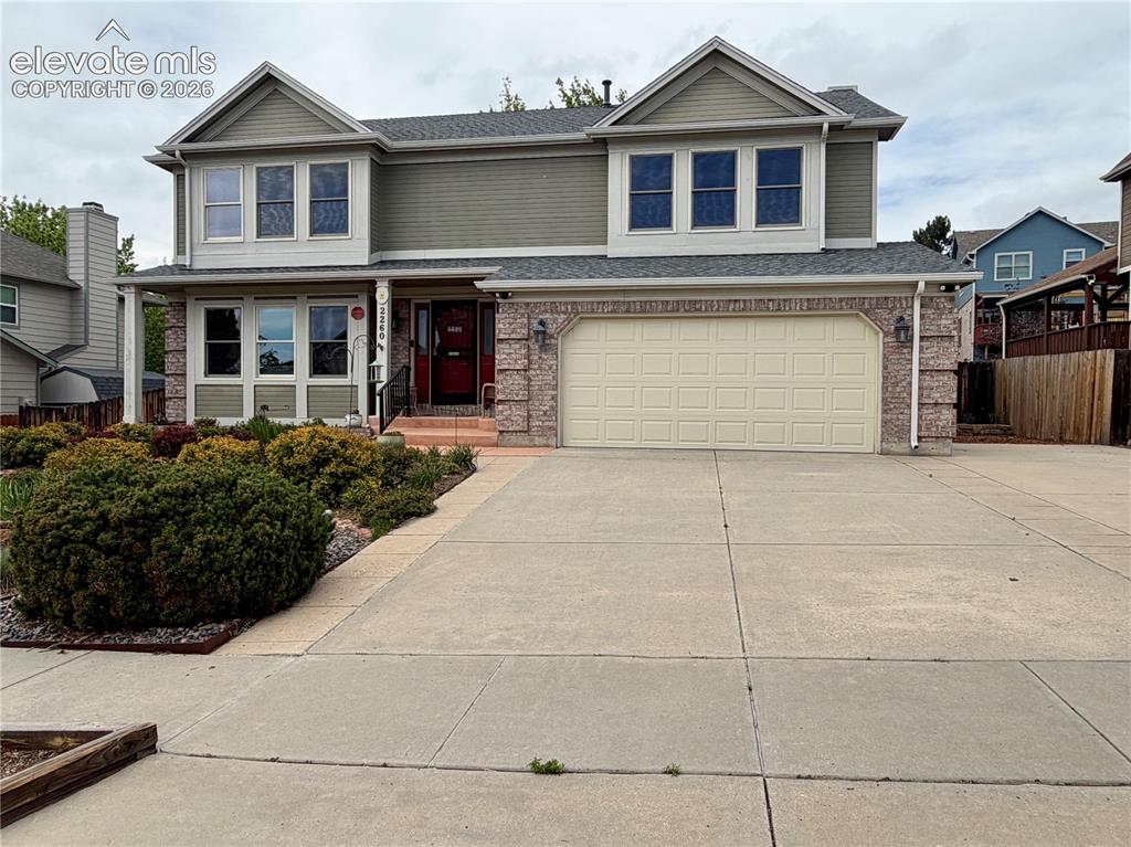Image 4 of 49: Two-story residence featuring a brick and siding exterior, an attached two-