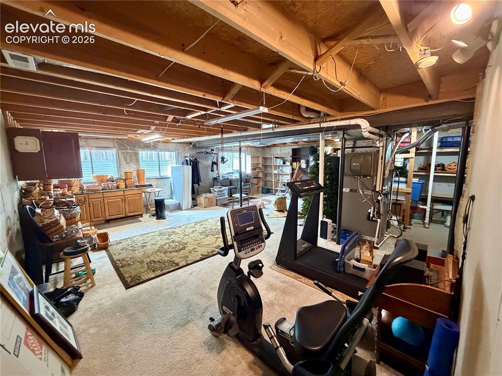Image 45 of 49: Unfinished basement space featuring multiple windows, built-in cabinetry, a