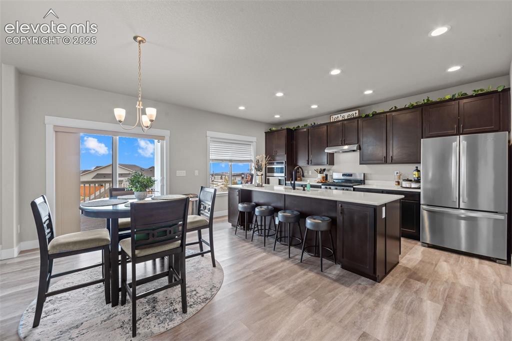Image 6 of 46: Quartz Counters, Gas Range, Eat in Dining area walks out to huge covered de