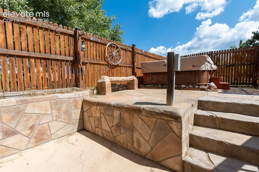 Image 28 of 36: Hot tub with privacy fence enclosed beautiful custom cement floor decking. 