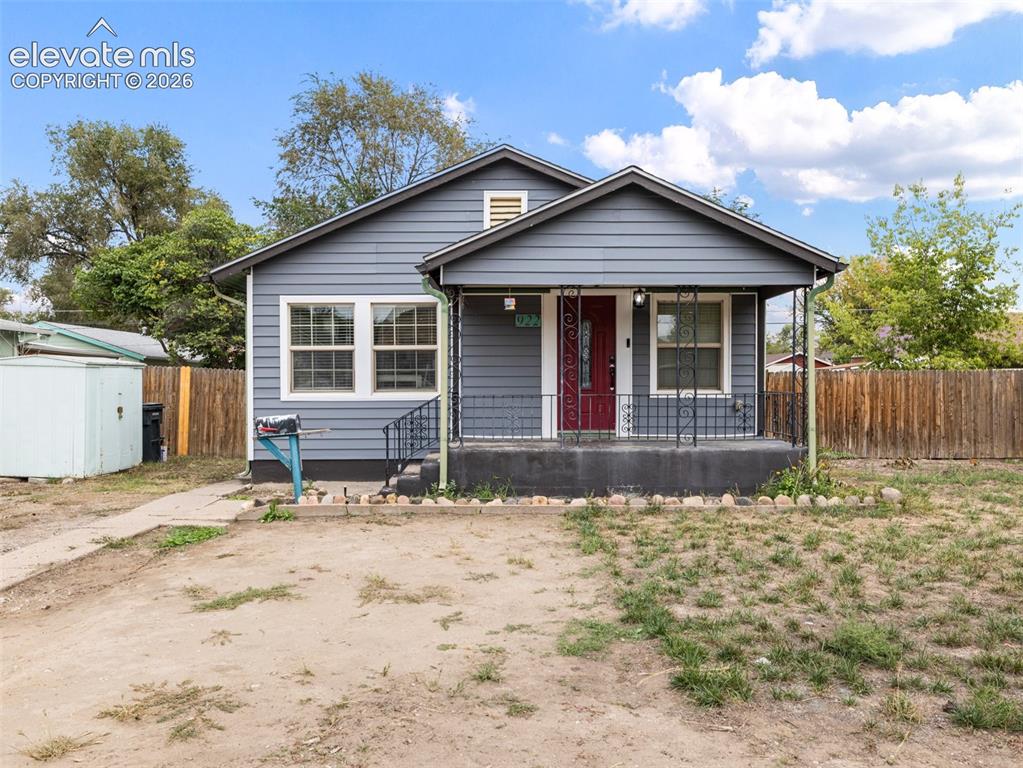 Image 1 of 26: Siding exterior with a covered front porch featuring decorative iron railin