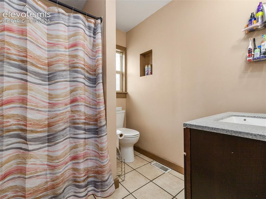 Image 17 of 26: Built-in vanity with a rectangular sink and light-colored countertop