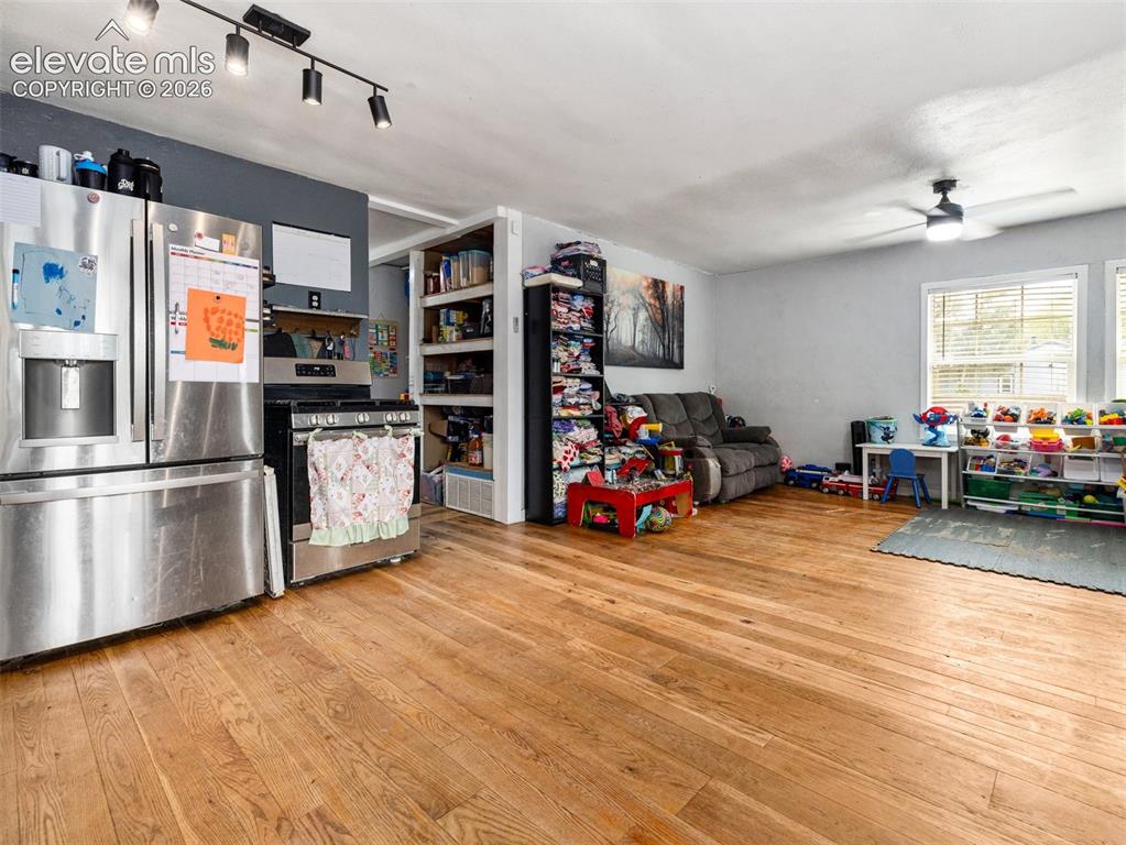 Image 6 of 26: Expansive wood-finish flooring, stainless steel kitchen appliances, track l