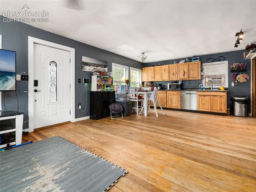 Image 8 of 26: Natural wood-finish flooring throughout, kitchen with wood cabinetry, stain