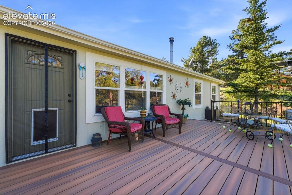 Image 16 of 50: Expansive composite deck with a black metal railing and multiple windows