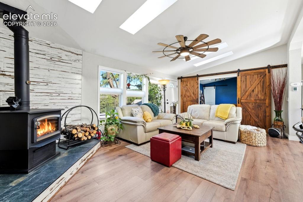 Image 20 of 50: Wood-finish flooring, vaulted ceiling with skylights, wood-burning stove wi