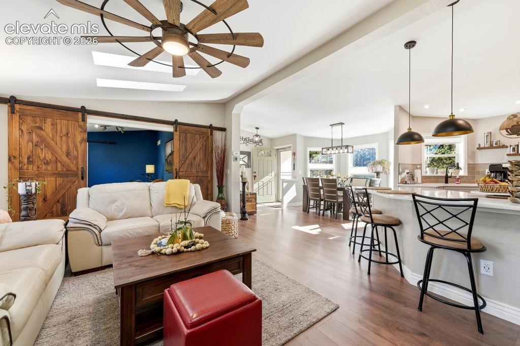 Image 22 of 50: Wood-finish flooring throughout, with a skylight and a ceiling fan with int