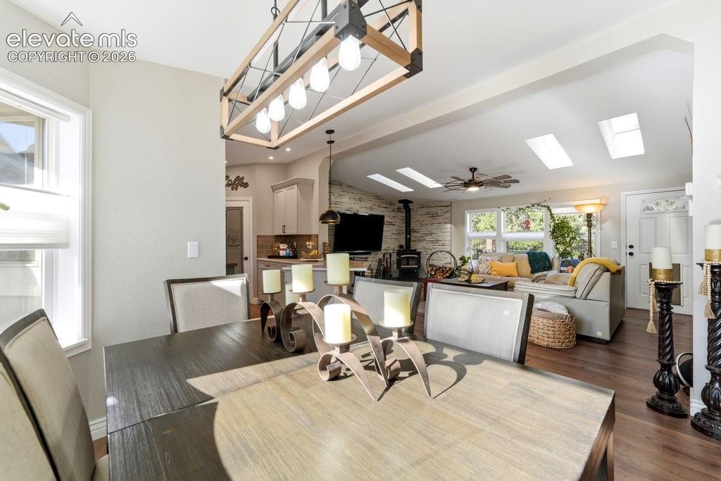 Image 24 of 50: Open-concept living space with wood-finish flooring, vaulted ceilings, and 