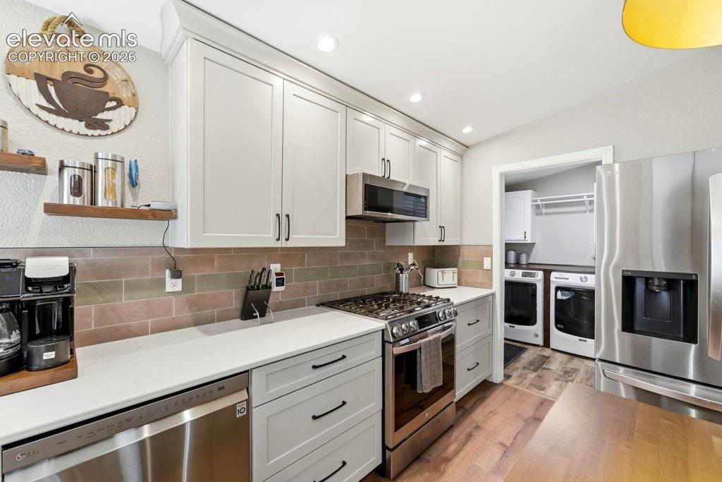 Image 29 of 50: White shaker cabinetry, stainless steel appliances, white countertops, subw