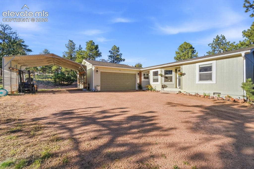 Image 3 of 50: Ranch-style exterior with light green siding, attached two-car garage, and