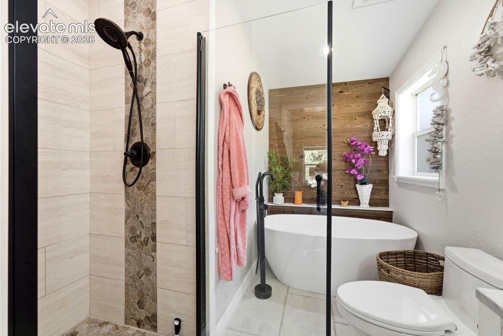 Image 37 of 50: Walk-in shower with stone-look tile surround and dark bronze fixtures
