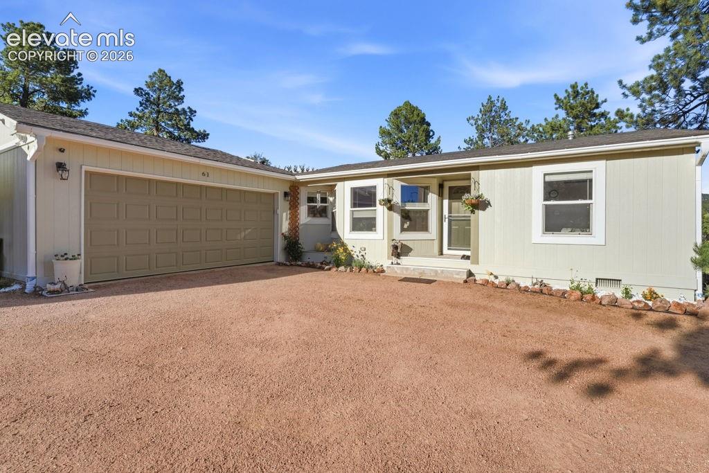 Image 4 of 50: Light-toned exterior with a two-car garage, multiple windows, and a covered