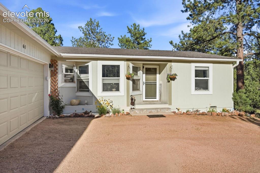 Image 5 of 50: Single-story residence featuring a two-car garage, light-colored exterior s