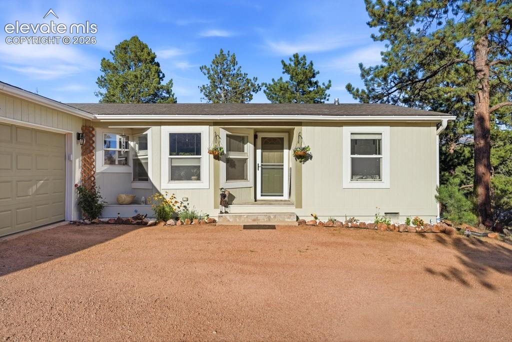 Image 6 of 50: Single-story exterior with light-colored siding, a dark roof, attached gara