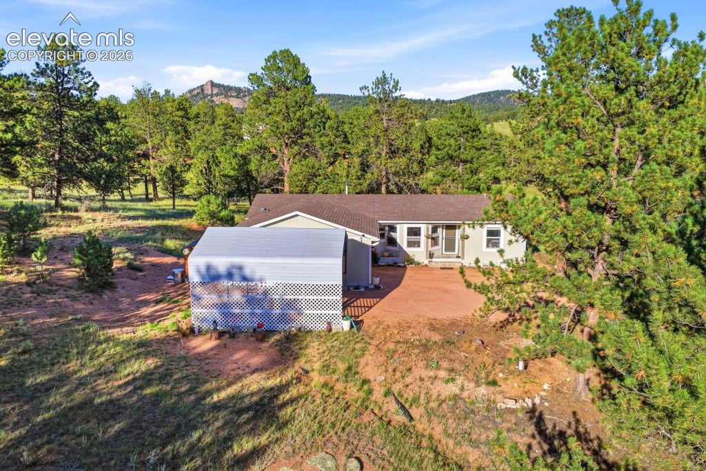 Image 7 of 50: Ranch-style residence featuring a light-toned exterior, a brown shingle roo