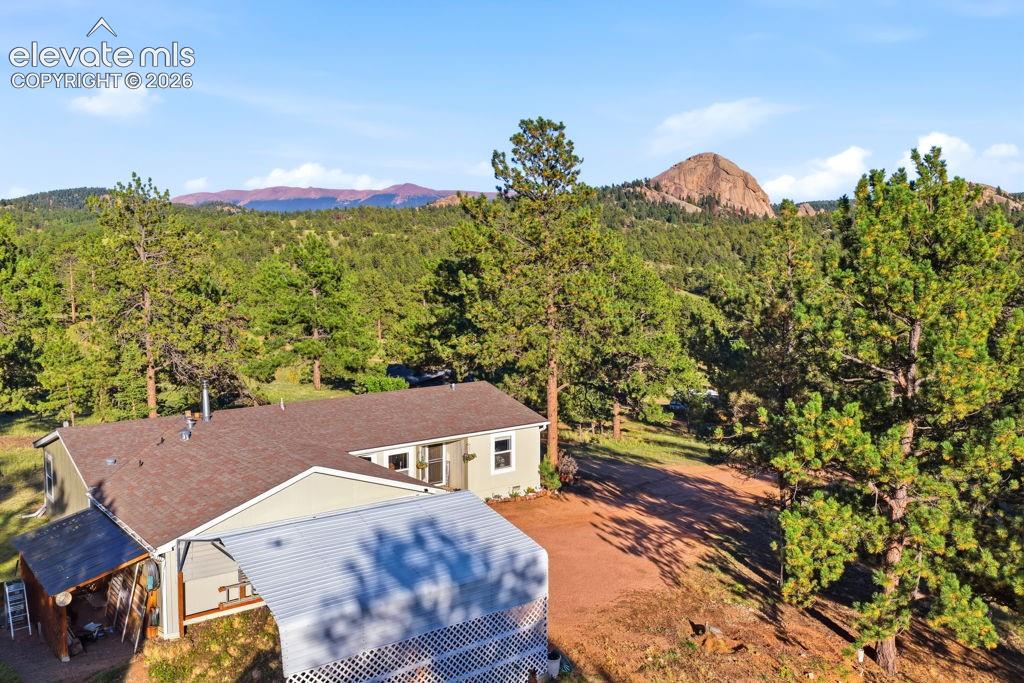 Image 8 of 50: Single-story residence with a brown shingle roof, light-colored siding, and