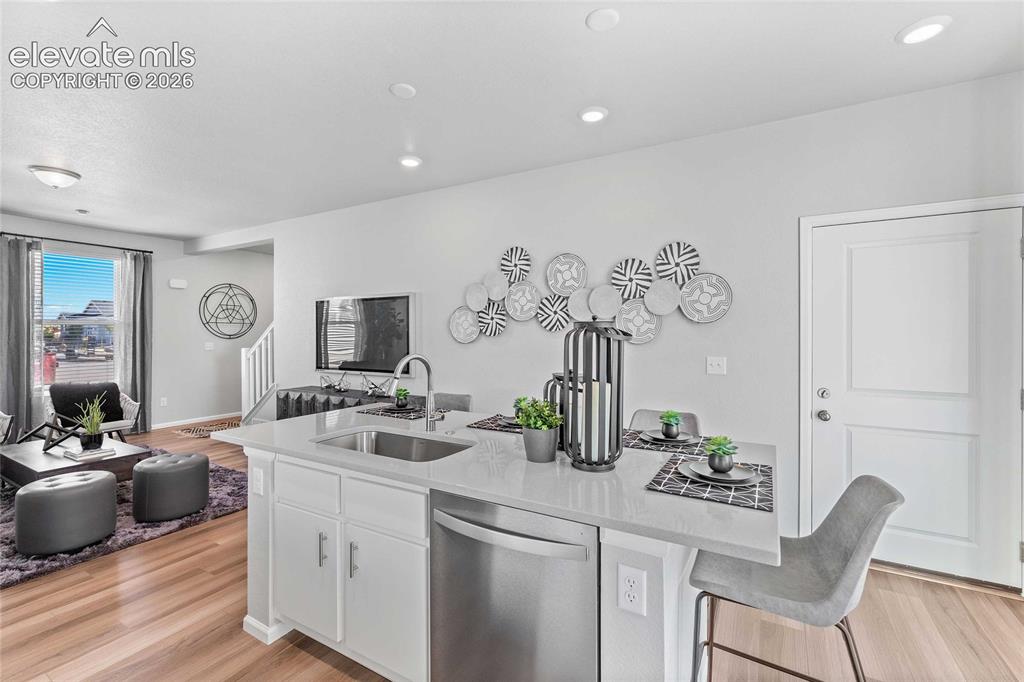 Image 10 of 25: Kitchen island with a stainless steel sink, sleek faucet, and integrated di