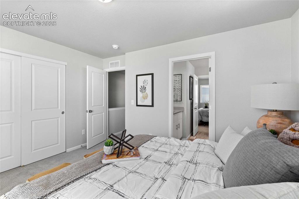 Image 20 of 25: Neutral wall paint, white trim, sliding closet doors, built-in closet shelv