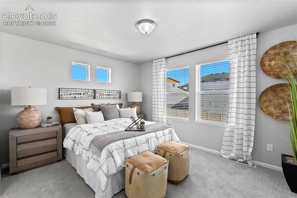 Image 21 of 25: Soft gray carpeting, large windows with white blinds, and two square high-s