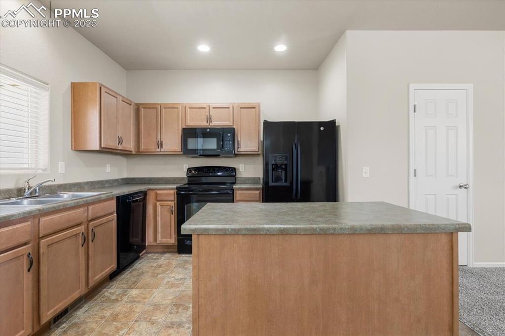 Image 10 of 42: Kitchen featuring black appliances, a kitchen island, and recessed lighting
