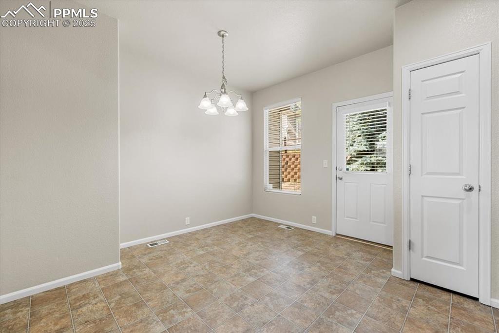 Image 17 of 42: Unfurnished dining area with baseboards and a chandelier