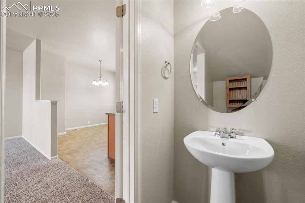 Image 18 of 42: Bathroom with a chandelier and baseboards