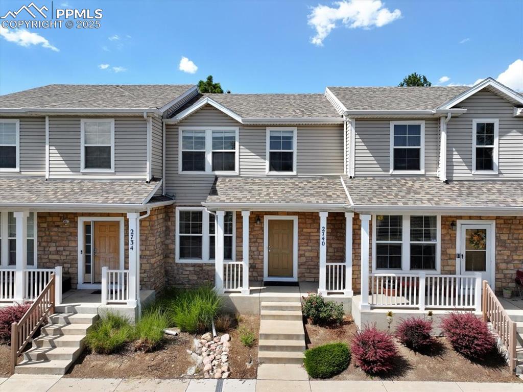 Image 2 of 42: Traditional-style home featuring covered porch, stone siding, and roof with