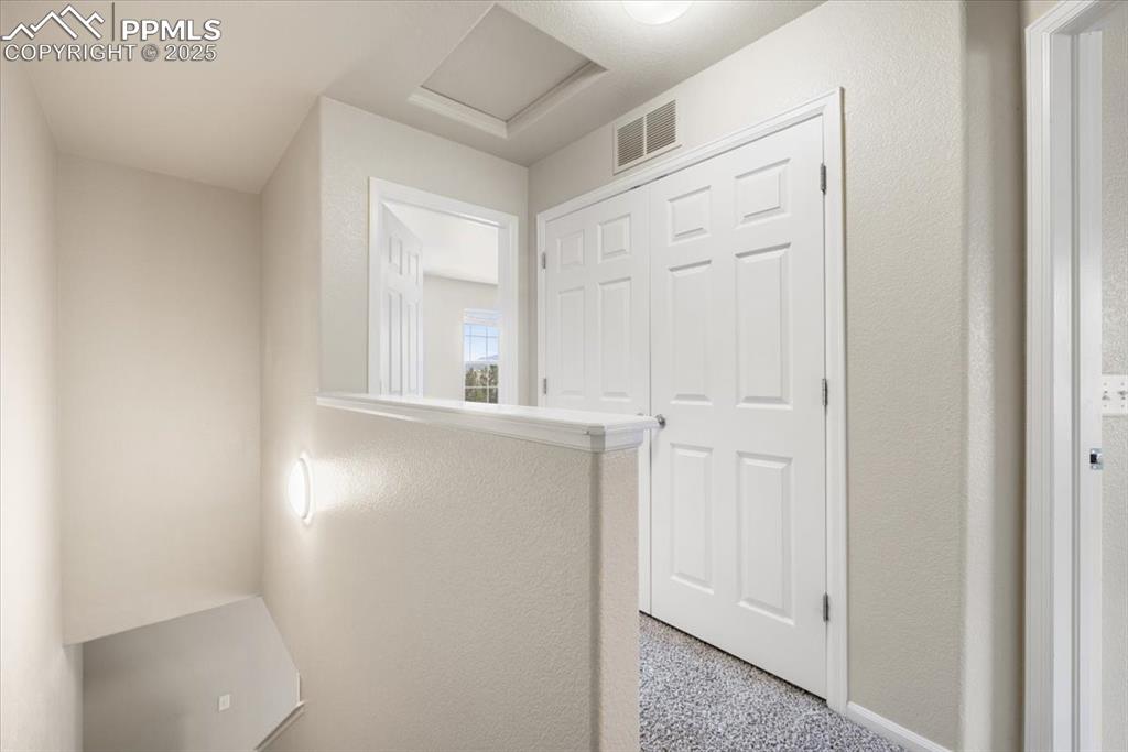 Image 20 of 42: Hall featuring a textured wall and attic access