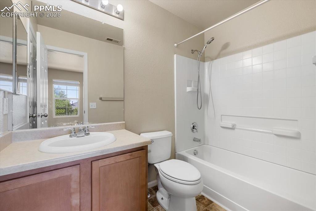 Image 24 of 42: Bathroom with shower / bath combination, vanity, and a textured wall