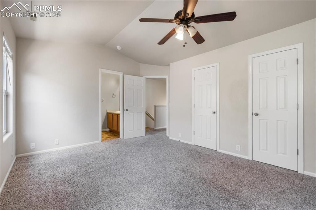 Image 29 of 42: Unfurnished bedroom featuring carpet floors, lofted ceiling, ensuite bathro