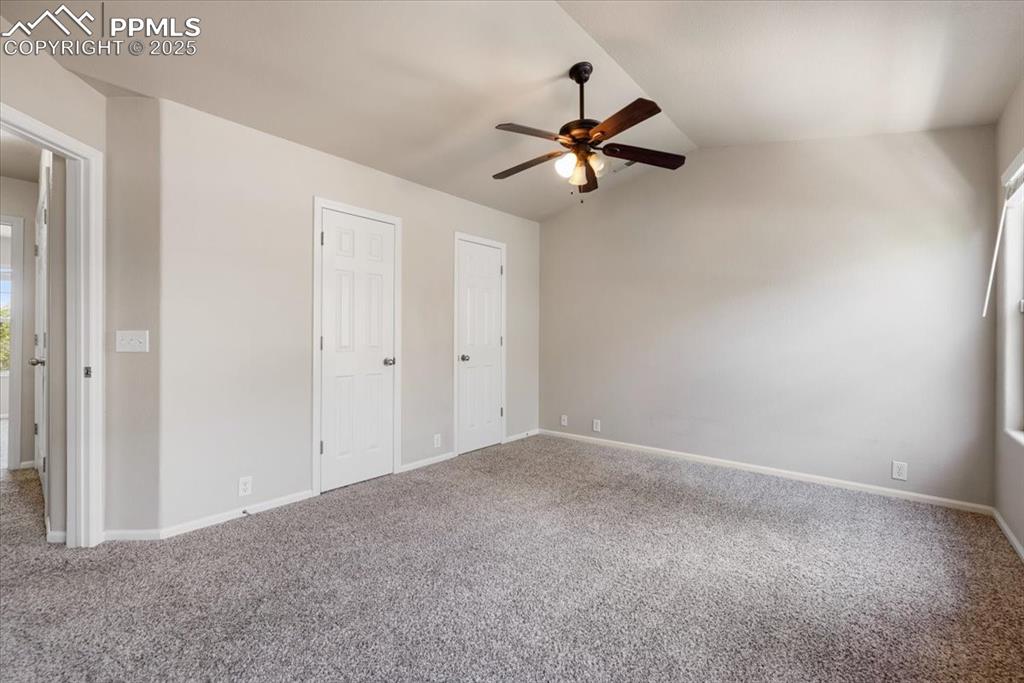 Image 30 of 42: Unfurnished bedroom featuring lofted ceiling, two closets, carpet, and ceil