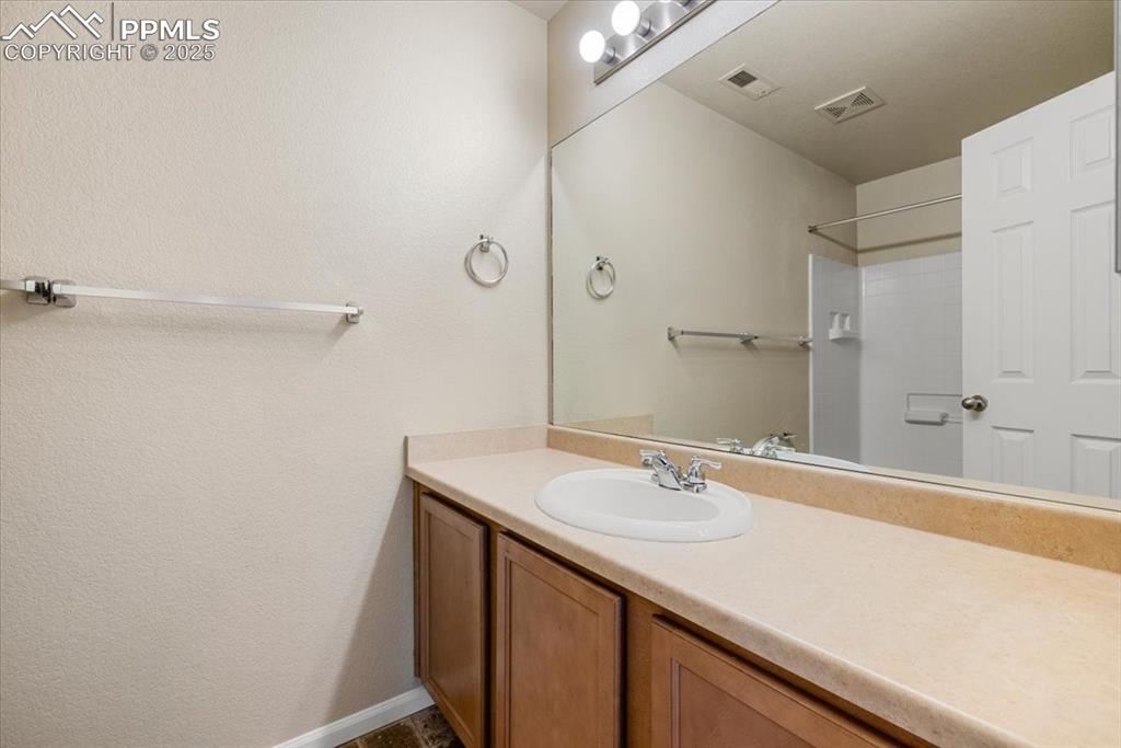 Image 31 of 42: Full bathroom with vanity and a textured wall