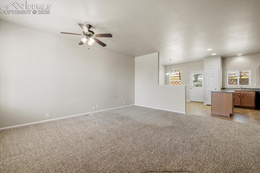Image 4 of 42: Unfurnished living room featuring light carpet, a ceiling fan, recessed lig