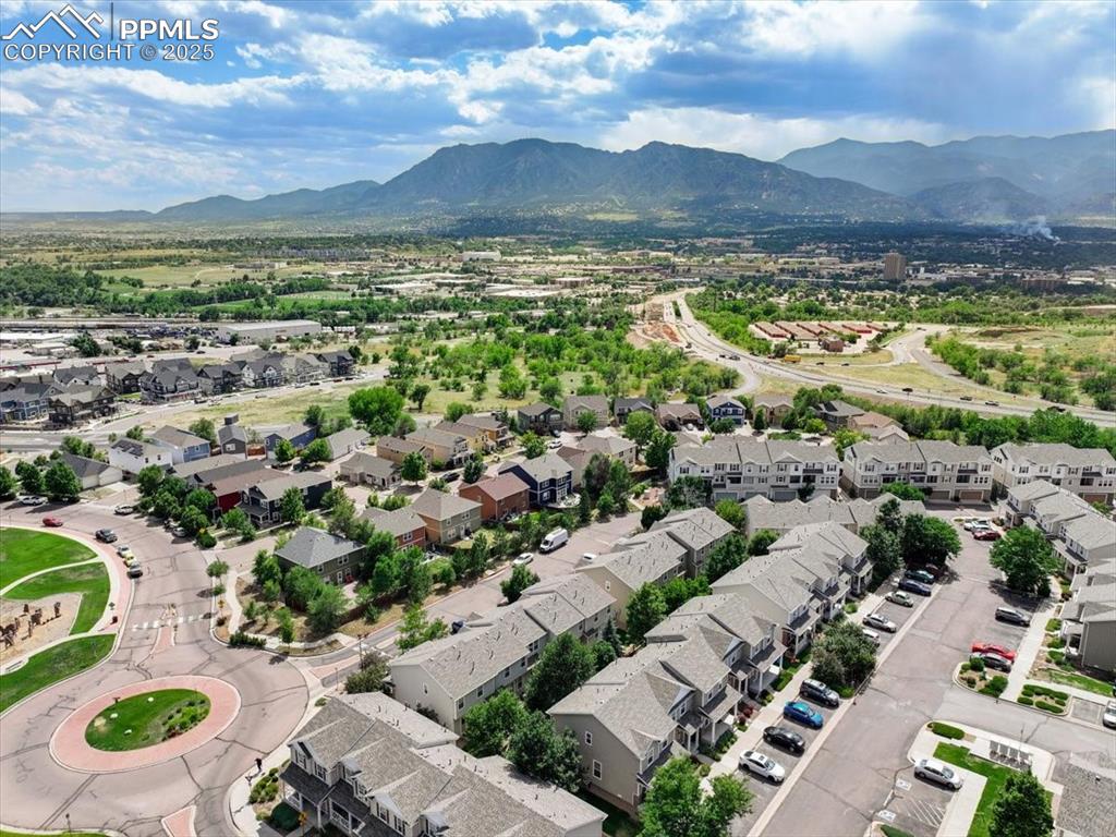 Image 42 of 42: Aerial view of residential area featuring a mountainous background
