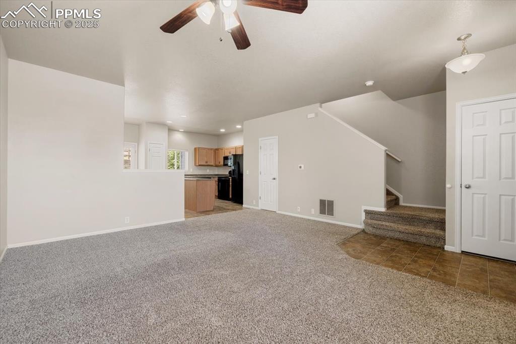 Image 5 of 42: Unfurnished living room featuring light colored carpet, ceiling fan, light