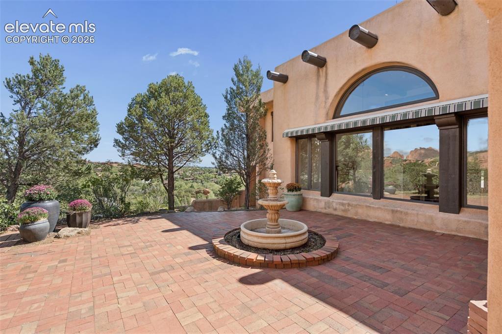 Image 16 of 46: The main patio creates an intimate outdoor gathering space surrounded by ma