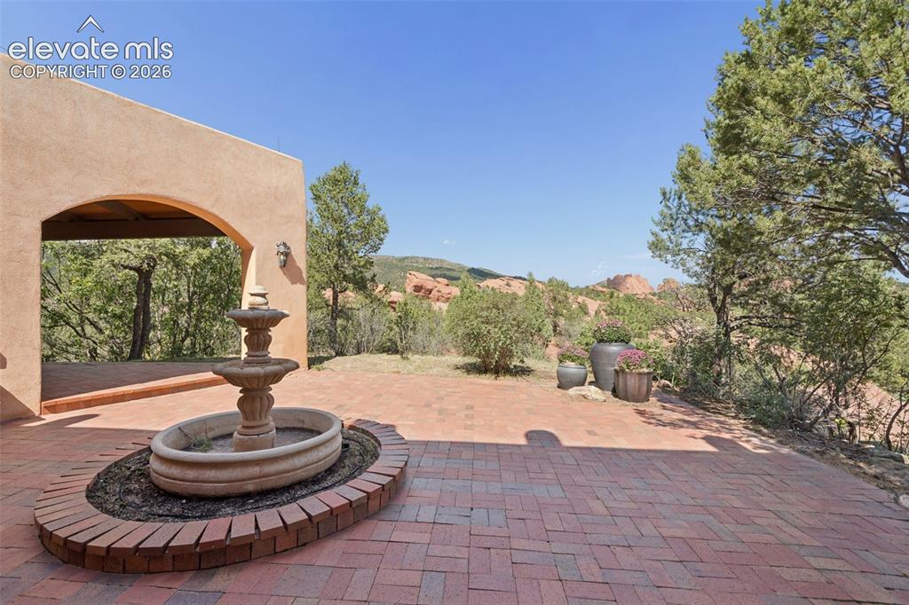 Image 17 of 46: An awning provides shade while the fountain adds a peaceful backdrop to out