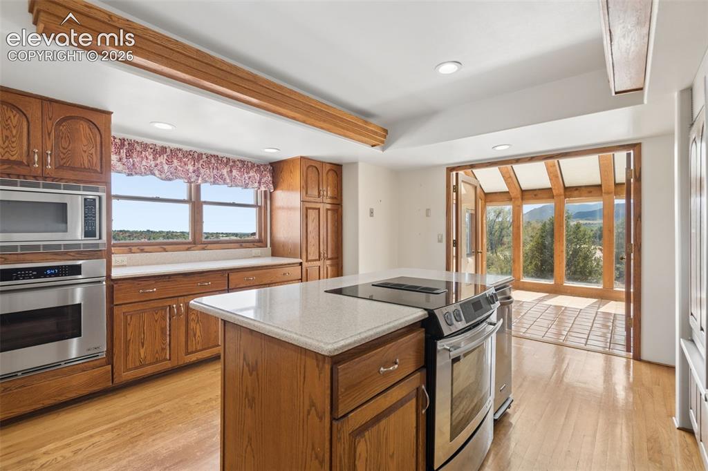 Image 26 of 46: Warm cabinetry and substantial counter space combine with natural light for