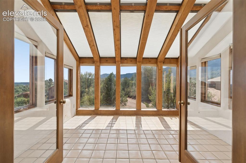 Image 28 of 46: Just beyond the kitchen, the south facing sunroom offers a light filled pla