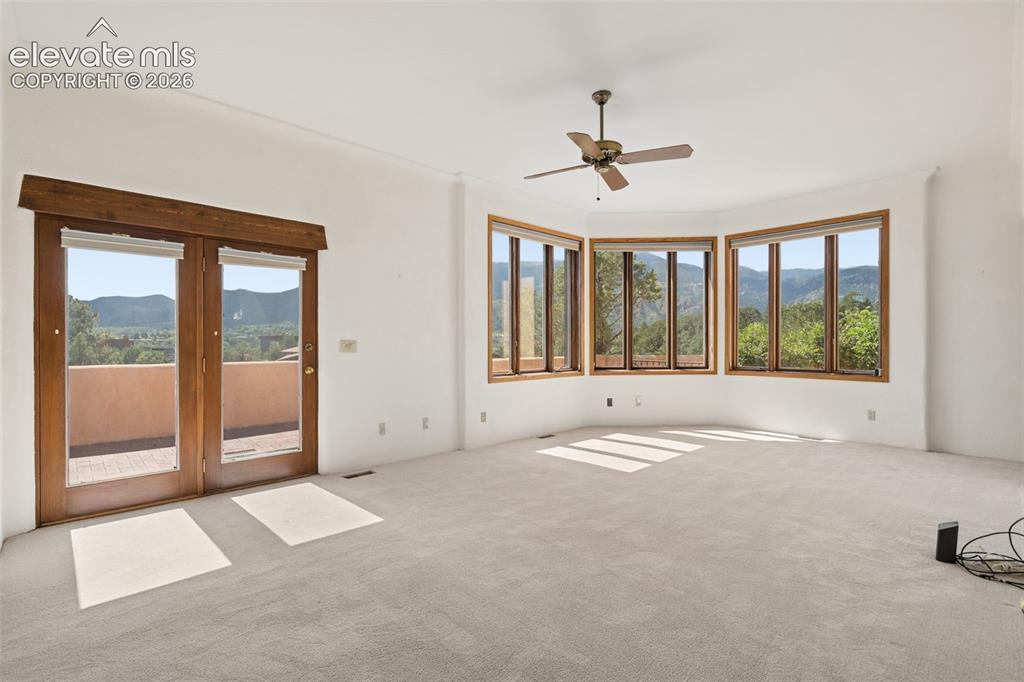 Image 29 of 46: Surrounded by windows, the upper family room opens directly to a secluded c