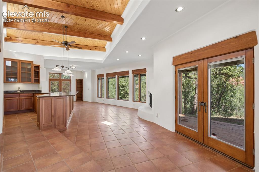 Image 34 of 46: Gather around the gas fireplace while expansive windows keep the surroundin