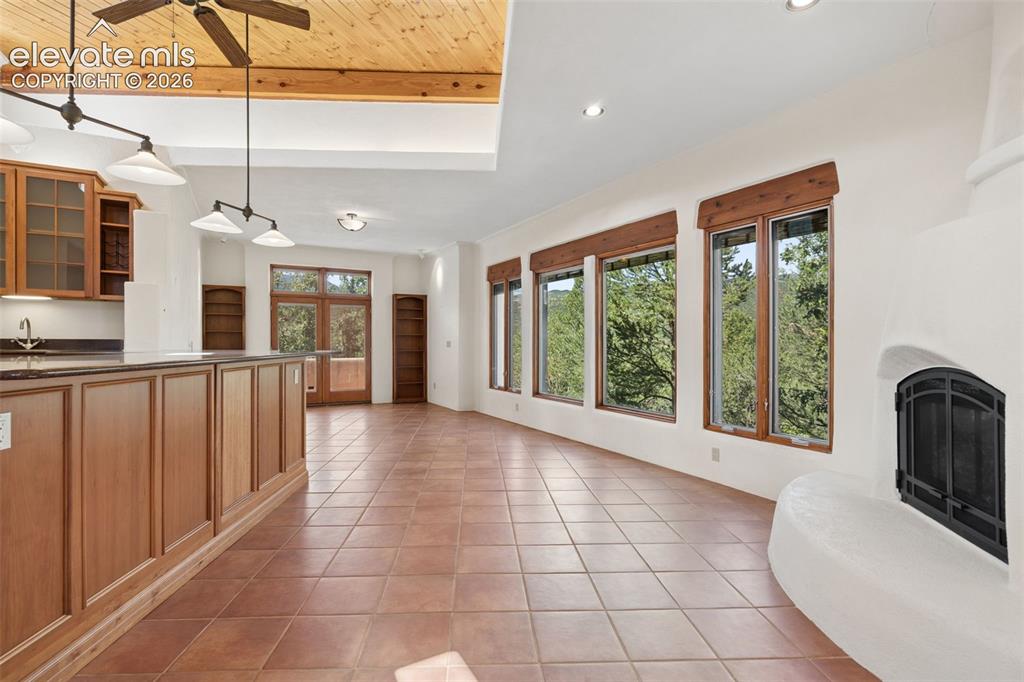 Image 35 of 46: Gather around the gas fireplace while expansive windows keep the surroundin