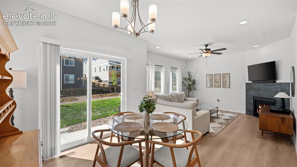Image 12 of 38: Open-concept living area featuring wood-finish flooring, a contemporary fir
